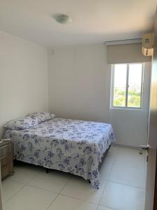 um quarto com uma cama e uma janela em Apartamento 3 quartos equipado em Maceió