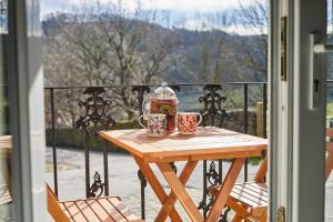 a wooden table with two cups on a balcony at Host & Stay - Ormesby in Greetland