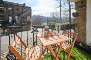 a wooden table and two chairs on a balcony at Host & Stay - Ormesby in Greetland