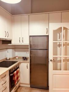 una cocina con nevera de acero inoxidable y armarios blancos en Bonito Piso con 2 habitaciones, en Porto do Son