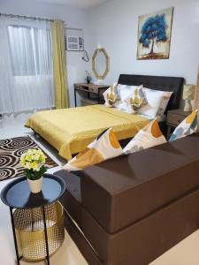 um quarto com uma cama e um sofá em DELUXE ROOM Queen Bed & Sofa Bed with Balcony and Swimming Pool at PPS em Puerto Princesa