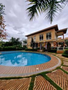 uma piscina em frente a uma casa em DELUXE ROOM Queen Bed & Sofa Bed with Balcony and Swimming Pool at PPS em Puerto Princesa