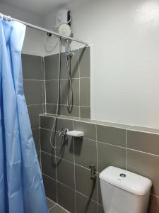 a shower in a bathroom with a toilet at DELUXE ROOM Queen Bed & Sofa Bed with Balcony and Swimming Pool at PPS in Puerto Princesa City