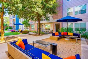 a patio with chairs and tables and an umbrella at Chic King Bed Desk w/ Pool in San Antonio