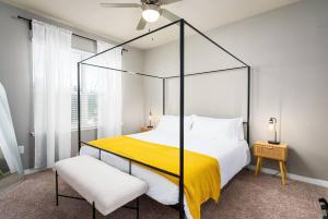 a bedroom with a canopy bed with a yellow blanket at Chic King Bed Desk w/ Pool in San Antonio
