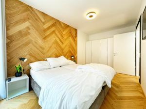 una camera con un grande letto e una parete in legno di LuxuryLake apartmán a Doksy