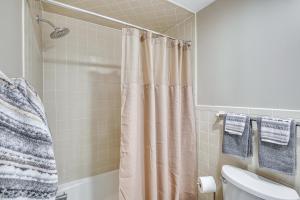 a bathroom with a shower curtain and a toilet at Ridgefield Cottage Walk to Town and Movie Theater! in Ridgefield