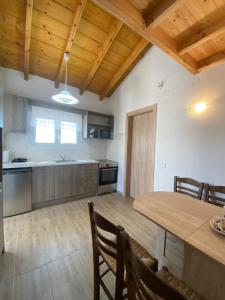 una cucina con tavolo in legno e soffitto in legno di Theo apartment a Marathias