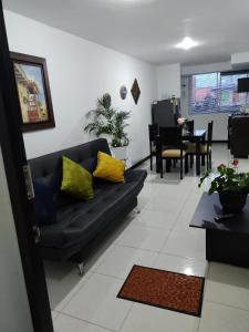a living room with a black couch and yellow pillows at Lindos Apartamentos Amoblados con piscina in Montenegro