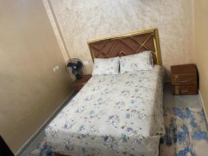 um quarto com uma cama com colcha floral em عقار الشرق الداخلة em Dakhla