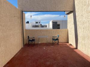 patio z 2 krzesłami i stołem w budynku w obiekcie عقار الشرق الداخلة w mieście Dakhla
