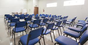 a room with blue chairs and tables in a classroom at Gold Hotel Navirai in Naviraí