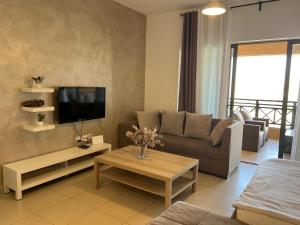 a living room with a couch and a tv at Spacious apartments with Sea view at Samarah Resort in Sowayma