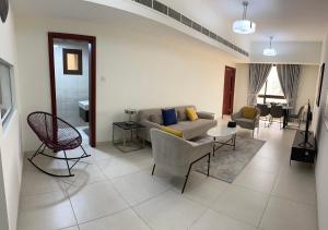 een woonkamer met een bank en een tafel bij City Gem BAQ in Muscat