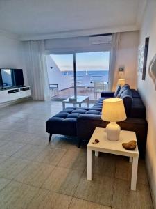 ein Wohnzimmer mit einem blauen Sofa und einem Tisch in der Unterkunft Caballito de Mar - Seahorse in Playa Blanca