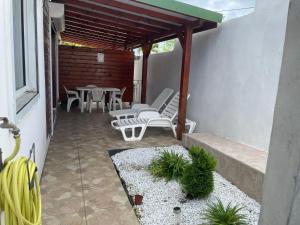 a patio with white chairs and a table and chairs at Appartement Hibiscus in Basse-Terre