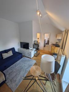 uma sala de estar com um sofá azul e uma mesa em Gerritz+Gäste em Meerbusch