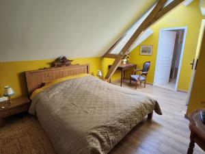 a bedroom with a bed and a desk in a room at La Perchonniere in Mamers