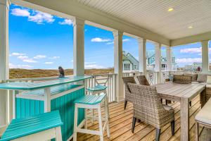 a porch with a table and chairs and a view of the ocean at Palmilla Beach Beauty in Port Aransas
