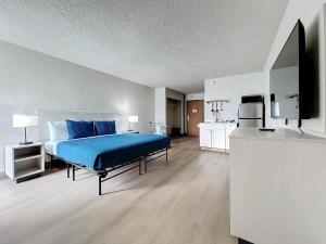 a bedroom with a bed with blue pillows at Stayable Kissimmee East in Kissimmee