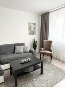 a living room with a couch and a coffee table at Jaukūs apartamentai Šilutėje in Šilutė