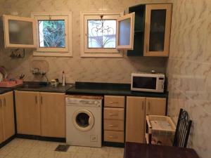 a kitchen with a washing machine and a microwave at Private villa North Coast in Dawwār Muḩammad Abū Shanab
