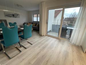 sala de estar con mesa, sillas y ventana grande en Moderne Apartments in zentraler Lage en Filderstadt