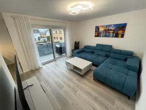 a living room with a blue couch and a table at Moderne Apartments in zentraler Lage in Filderstadt