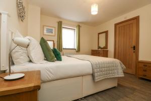 een slaapkamer met een bed, een tafel en een lamp bij The Lily Pad in Camborne