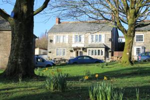 a large stone house with cars parked in front of it at Dick Cottage in Bodmin