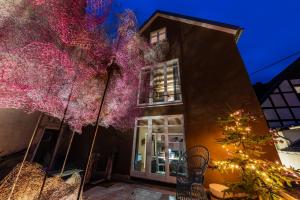 un edificio con un árbol delante de él en Arthostel Martine en Unkel