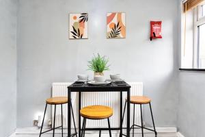 a black table with three chairs and a plant on it at Everest Home in Nottingham