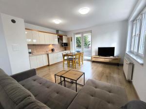 ein Wohnzimmer mit Sofa und Tisch in der Unterkunft Apartamenty-Plaza Kołobrzeg in Kołobrzeg