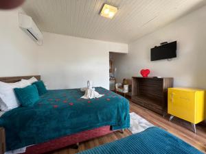 um quarto com uma cama e uma televisão na parede em Apartamentos de Altitude Urubici em Urubici
