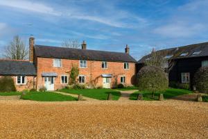 a large red brick house with a yard at Charming Barn Retreat Near Pewsey & Woodborough in Woodborough