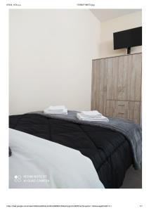 a bed with a black and white blanket on it at D&K Studio - Nafplio in Nafplio