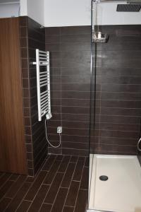 a bathroom with a shower with brown tiles at Stefano's Apartment in Bari +38 photos