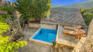 uma vista superior de uma piscina com 2 espreguiçadeiras em Villa Historic Pocitelj with pool and incredible views on the river and landmarks em Počitelj