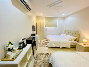 een hotelkamer met 2 bedden, een bureau en een kamer bij Haven in Mekka