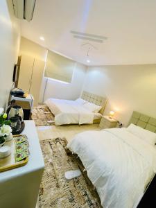 a bedroom with two beds and a desk and a bed at Haven in Makkah