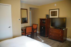 a bedroom with a bed and a television and a table at Hotel Boston in Boston