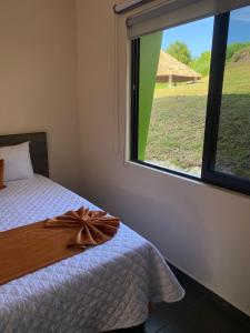 a bedroom with a bed with a large window at LOS BAMBUES HOTEL in La Tinaja