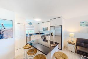 a kitchen with a stainless steel refrigerator and stools at La Nereida in Marathon
