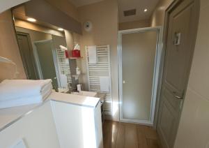 a bathroom with a white sink and a mirror at La Maison Du 6 in Arromanches-les-Bains