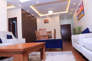 ein Wohnzimmer mit einem Sofa und einem Tisch in der Unterkunft Very secure apartment Bole Addis Enyi Real Estate in Addis Abeba