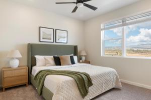 1 dormitorio con 1 cama con cabecero verde y ventana en Desert Daze Hideaway condo, en St. George