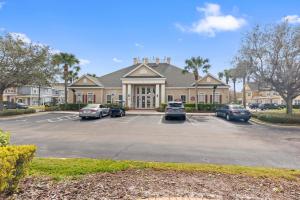 a large house with cars parked in a parking lot at The Villas at Seven Dwarfs - 4564 Luxury Villa - Near Disney - Water Park in Kissimmee