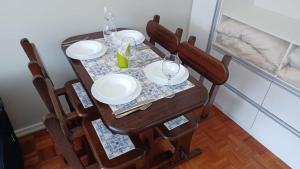 a dining room table with plates and glasses on it at ACONCHEGO DA SERRA in Teresópolis