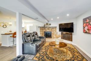a living room with a leather couch and a fireplace at Pet-Friendly Woodbridge Retreat Near Potomac Mills in Woodbridge