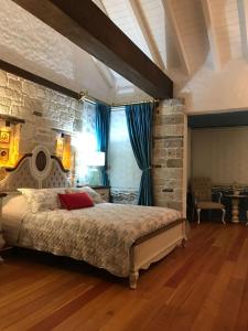 una camera con un grande letto e un muro di mattoni di VİA PERLA BUTİK OTEL a Çiftlikköyü